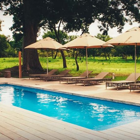 Piscine en plein air avec transats et parasols à Fathala.