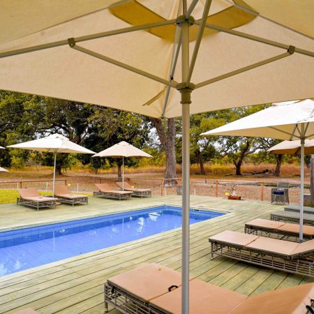 Terrasse avec piscine et parasols à la Réserve de Fathala.