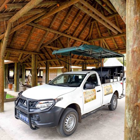 Véhicule de safari garé sous un abri en bois à Fathala.