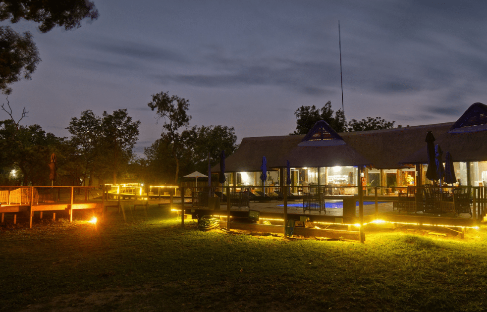 Lodge de Fathala au crépuscule avec lumières chaleureuses.